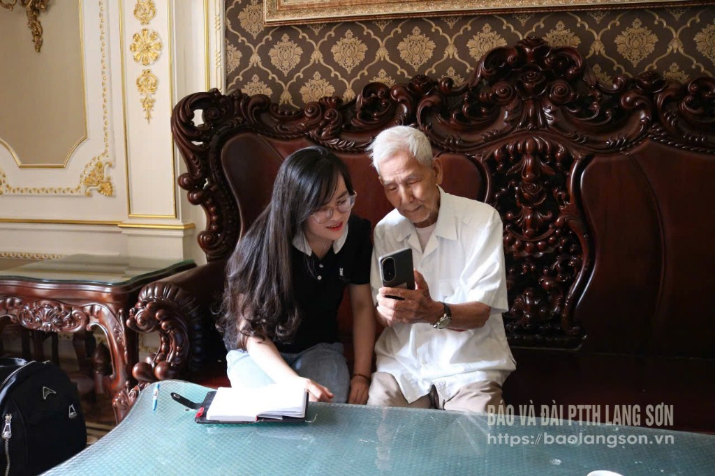Ông Đặng Xuân Mai chia sẻ với phóng viên những kỷ niệm được lưu giữ trên điện thoại trong chuyến thăm chiến trường xưa nhân kỷ niệm Chiến thắng Điện Biên Phủ