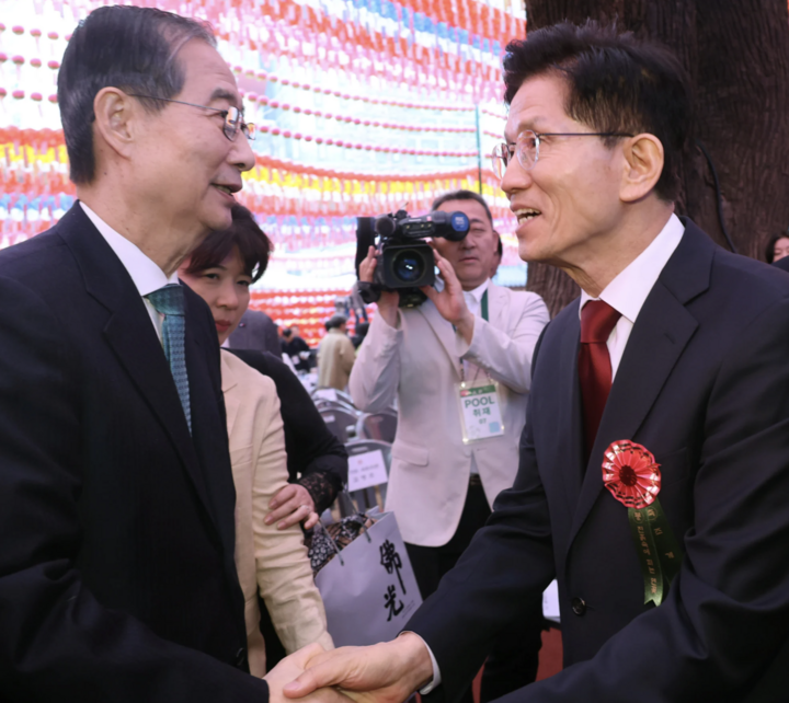 Ông Kim Moon-soo (phải), ứng cử viên Tổng thống của đảng Quyền lực Nhân dân Hàn Quốc, bắt tay ông Han Duck-soo. (Ảnh: SCMP)