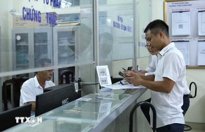 Người dân đến làm thủ tục hành chính. (Ảnh: Công Luật /TTXVN)