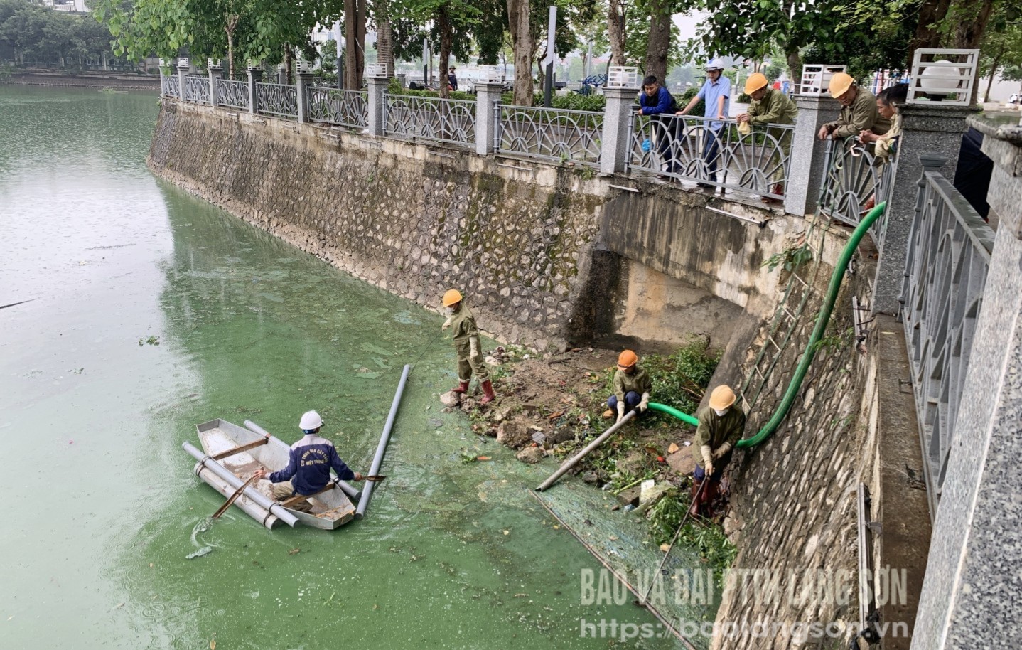 Nhân viên 2 công ty dùng phương tiện dồn các mảng váng để hút, vớt lên