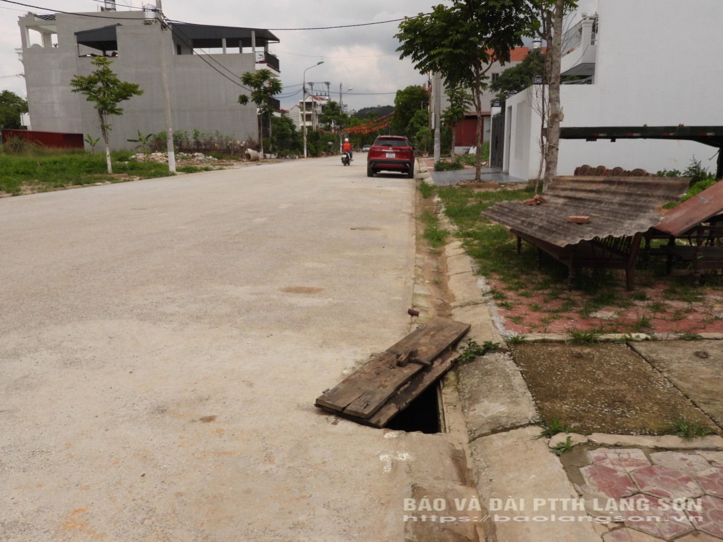 Người dân sử dụng tấm gỗ che đi phần hố lộ thiên để bớt nguy hiểm khi tham gia giao thông