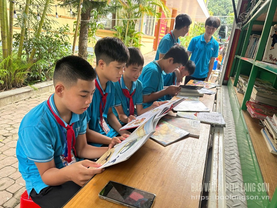 Các em học sinh đọc sách tại xe ô tô thư viện lưu động