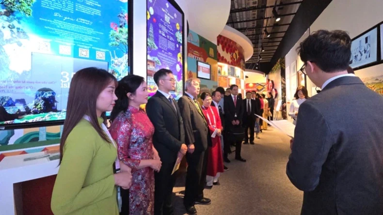 Các đại biểu tham quan, nghe thuyết minh các nội dung trưng bày tại triển lãm.