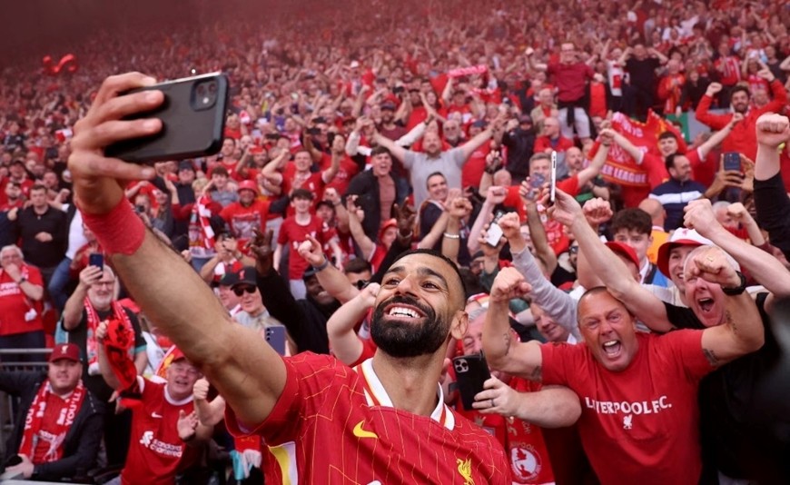 Tiền đạo Mohamed Salah chụp ảnh cùng cổ động viên Liverpool. Ảnh: Reuters