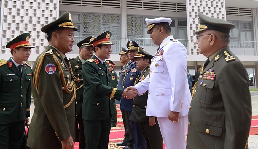 Đại tướng Vong Pisen, Tổng tư lệnh Quân đội Hoàng gia Campuchia giới thiệu với Đại tướng Nguyễn Tân Cương các thành viên đoàn đại biểu quân sự cấp cao Bộ Tổng tư lệnh Quân đội Hoàng gia Campuchia tại lễ đón.  