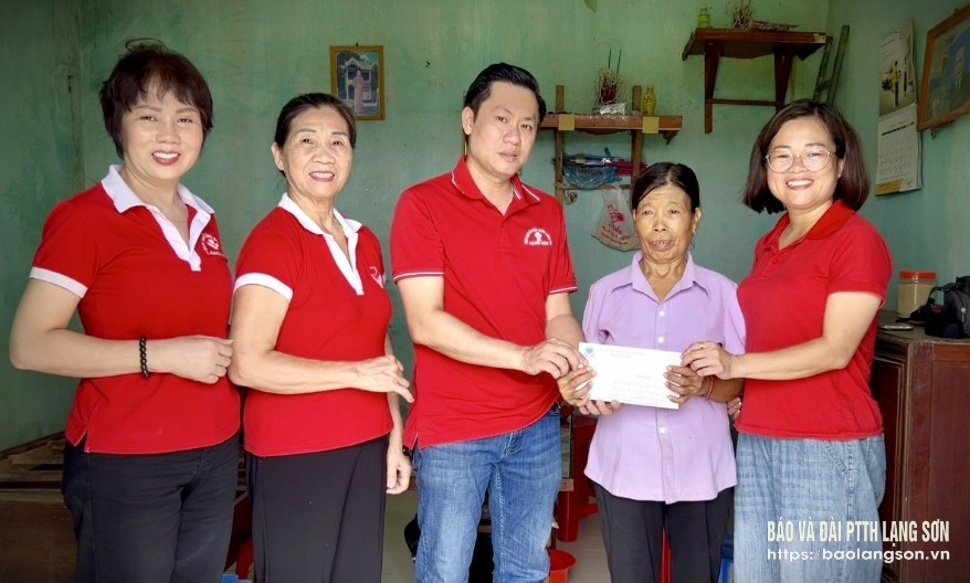 Đại diện Câu lạc bộ Thắp sáng niềm tin và Hội Chữ thập đỏ huyện Đình Lập trao kinh phí gắn địa chỉ nhân đạo cho gia đình bà Hoàng Thị Pháy, thôn Tà Hón, xã Đình Lập, huyện Đình Lập