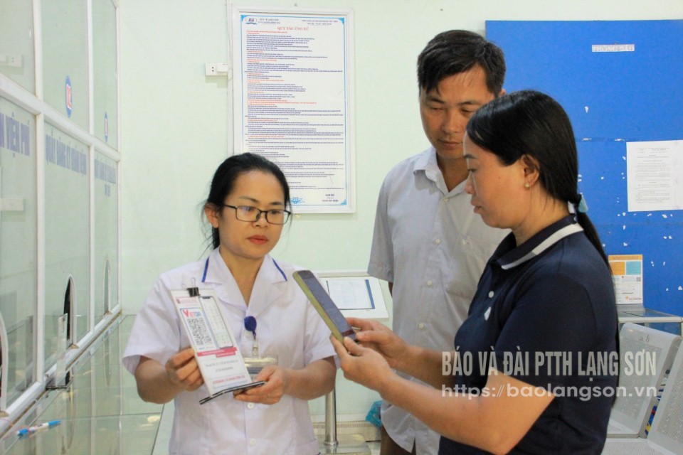 Nhân viên Trung tâm Y tế huyện Bình Gia hướng dẫn người dân thanh toán viện phí không dùng tiền mặt