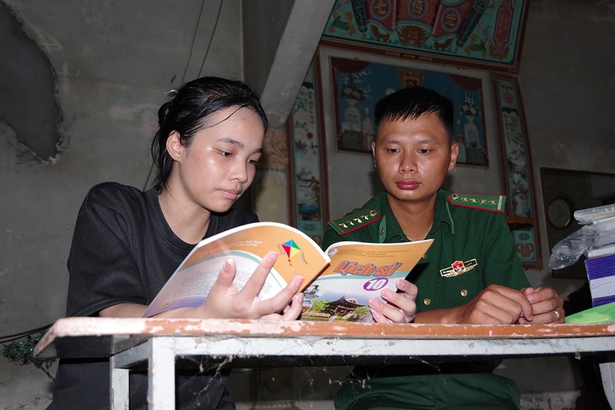 Cán bộ Đồn Biên phòng Vinh Quang giúp đỡ học sinh học tập trên địa bàn xã Vinh Quang, huyện Tiên Lãng. Ảnh: NGUYỄN KHÁNH