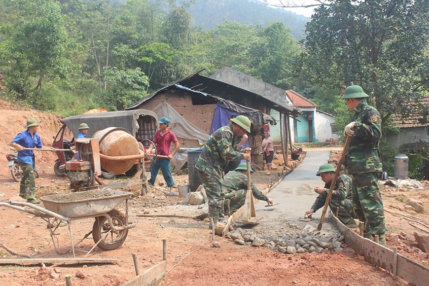 Cán bộ, nhân viên, trí thức trẻ tình nguyện Lâm trường 156 (Đoàn Kinh tế-Quốc phòng 327) tham gia giúp đỡ nhân dân khu dân cư Trình Tường đổ bê tông đường vào bản.