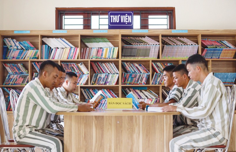 Các phạm nhân đọc sách trong Trại giam Thanh Xuân.