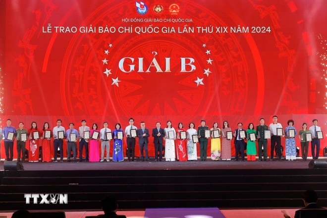 Phó trưởng Ban thường trực Ban Tuyên giáo và Dân vận Trung ương Lại Xuân Môn và Chủ tịch Hội Nhà báo Nhân Dân, Tổng Biên tập Báo Nhân Dân Lê Quốc Minh trao giải B cho các tác giả, nhóm tác giả đoạt giải. (Ảnh: Minh Quyết/TTXVN)