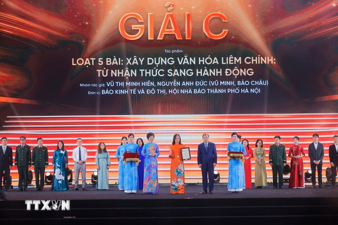 Tổng giám đốc TTXVN Vũ Việt Trang và Thứ trưởng Thường trực Bộ Văn hóa, Thể thao và Du lịch Lê Hải Bình trao giải C cho các tác giả, nhóm tác giả đoạt giải. (Ảnh: Minh Quyết/TTXVN)
