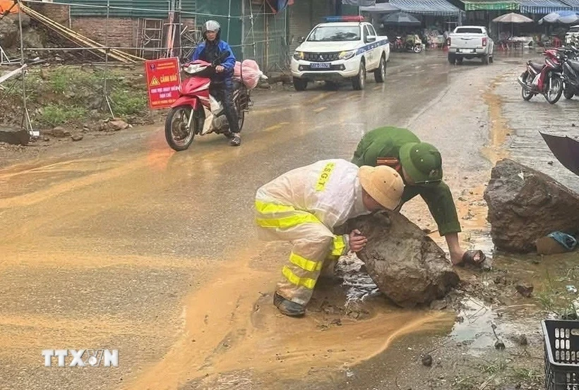 Cảnh sát giao thông huyện Bảo Lạc (Cao Bằng) khắc phục hiện tượng sạt lở đất đá do mưa lớn, tạo thuận lợi cho người tham gia lưu thông. (Ảnh: TTXVN phát)