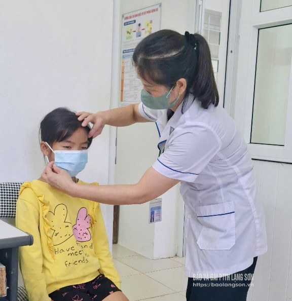 Cán bộ Trung tâm Kiểm soát bệnh tật tỉnh hướng dẫn trẻ nhỏ đeo khẩu trang đúng cách