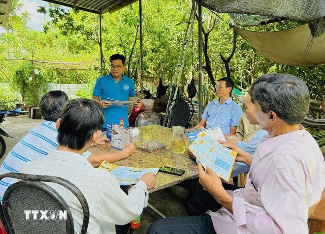 Cán bộ Bảo hiểm Xã hội tỉnh Hậu Giang tuyên truyền chính sách bảo hiểm cho người dân. (Ảnh: TTXVN phát)