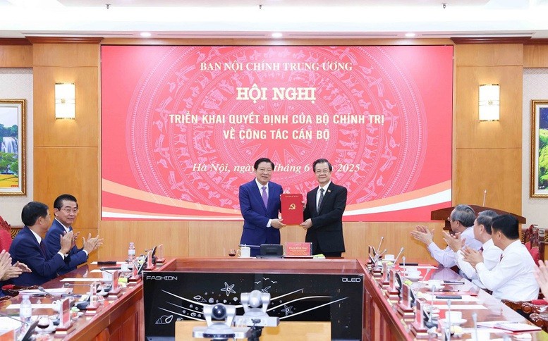 Đồng chí Phan Đình Trạc, Ủy viên Bộ Chính trị, Bí thư Trung ương Đảng, Trưởng Ban Nội chính Trung ương trao Quyết định và tặng hoa chúc mừng đồng chí Lê Hồng Quang
