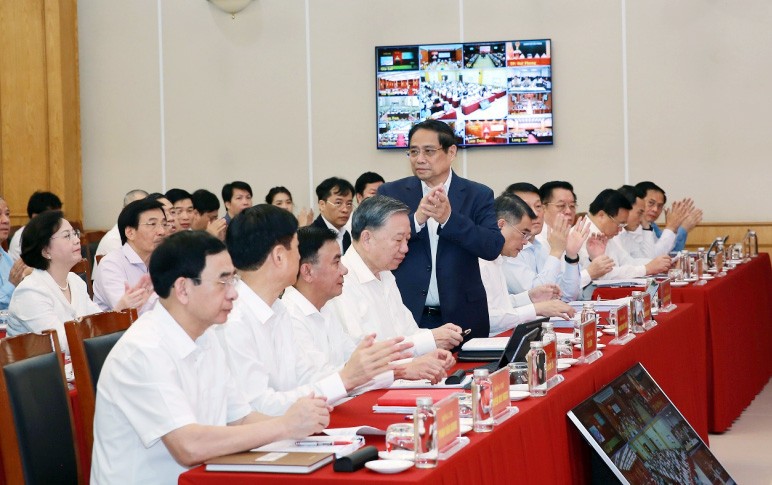 Các đại biểu chào mừng Thủ tướng Chính phủ Phạm Minh Chính tham dự hội nghị.