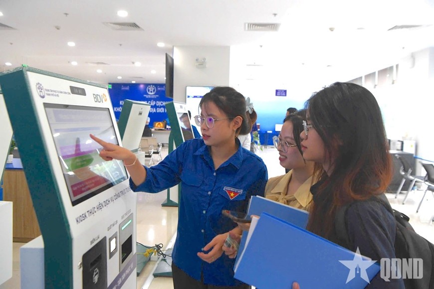   Đoàn viên, thanh niên hỗ trợ người dân tra cứu thông tin tại Trung tâm Phục vụ hành chính công TP Hà Nội. Ảnh: THÁI HƯNG