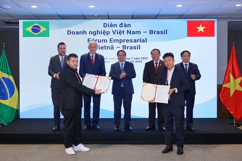 Thủ tướng Phạm Minh Chính và các đại biểu chứng kiến lễ trao thỏa thuận hợp tác giữa Công ty Cổ phần Nam Việt (NAVICO) và AV09 Comercio Exporter Ltda trong lĩnh vực thủy sản - Ảnh: VGP/Nhật Bắc