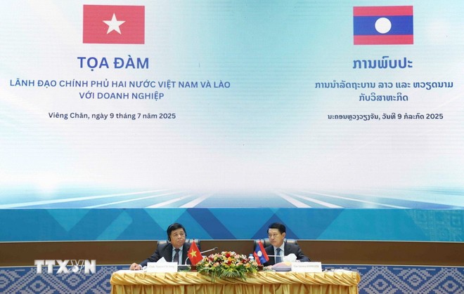 Phó Thủ tướng Nguyễn Chí Dũng và Phó Thủ tướng Lào Saleumxay Kommasith (phải) đồng chủ trì Tọa đàm giữa Lãnh đạo Chính phủ hai nước với doanh nghiệp. (Ảnh: Xuân Tú/TTXVN)