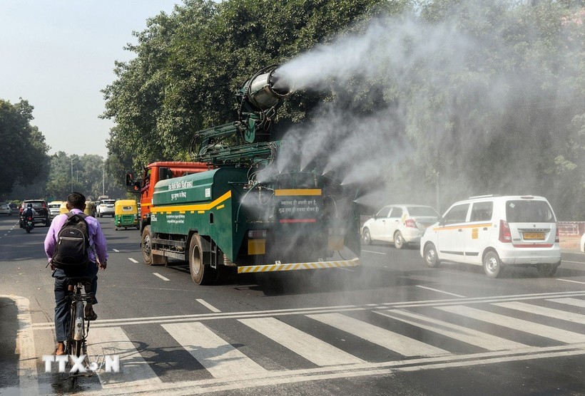Phun nước trên đường phố để làm giảm tình trạng ô nhiễm không khí tại New Delhi, Ấn Độ. (Ảnh: ANI/TTXVN)