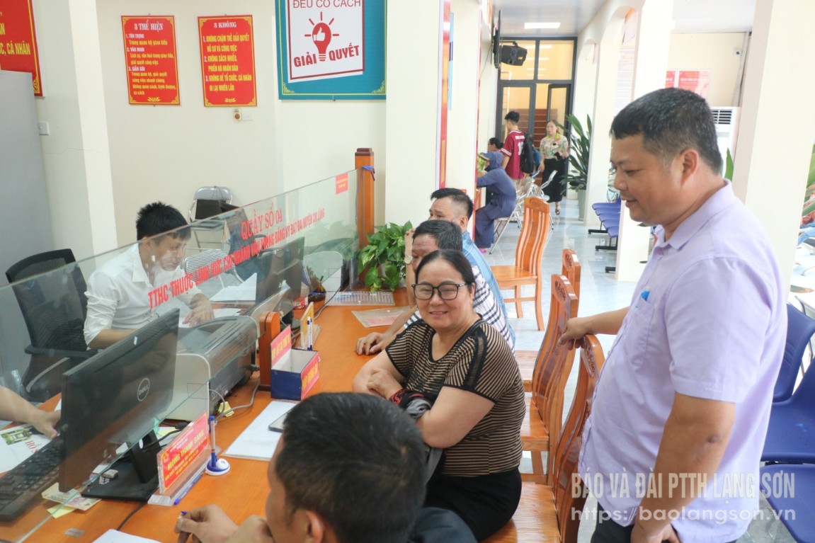 Cán bộ, công chức Trung tâm Phục vụ hành chính công xã Chi Lăng trao đổi với người dân khi đến thực hiện thủ tục hành chính
