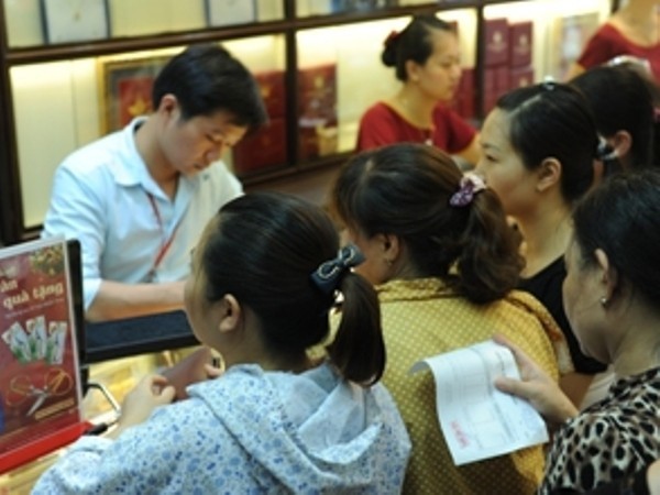 Khách hàng giao dịch vàng tại Hà Nội. (Ảnh: Vietnam+)