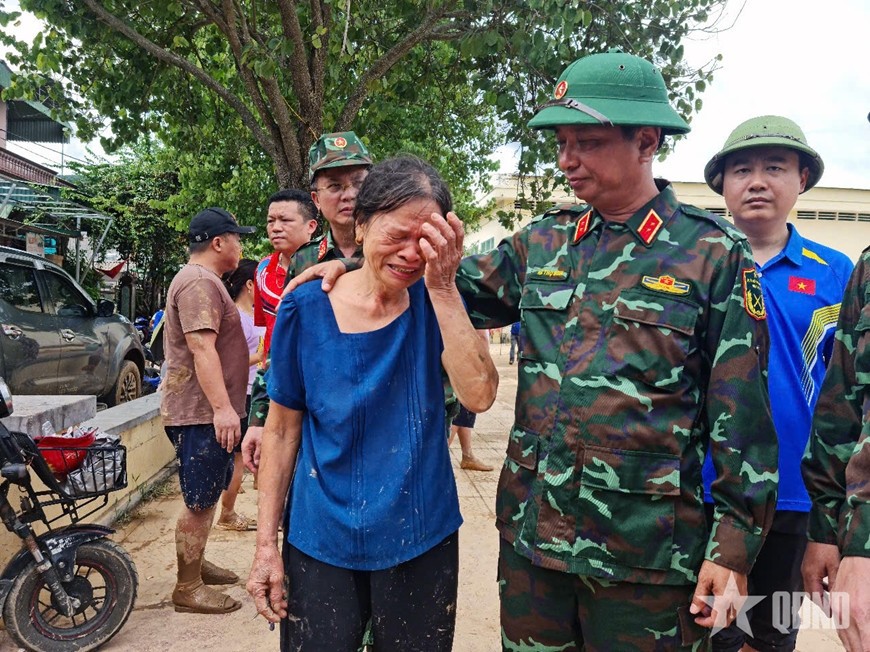 Người dân vùng lũ bật khóc khi gặp lãnh đạo Bộ tư lệnh Quân khu 4 cùng trực thăng vận chuyển hàng cứu trợ đến tâm lũ. Ảnh: ANH TẦN
