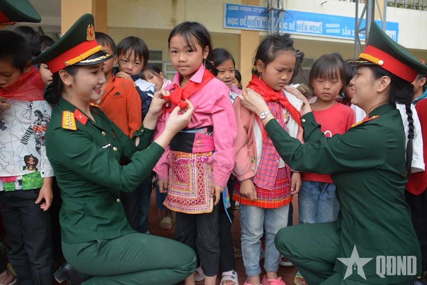 Mỗi chuyến công tác đến vùng sâu, vùng xa, Đại úy QNCN Nguyễn Thị Mỹ Linh (bên trái) và các đồng nghiệp tại Nhà hát luôn chuẩn bị nhiều món quà tặng các cháu học sinh.