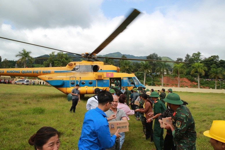 Phó Thủ tướng Trần Hồng Hà cùng nhân dân chuyển nhu yếu phẩm từ máy bay trực thăng để đưa đến các khu vực cần hỗ trợ - Ảnh: VGP/Minh Khôi