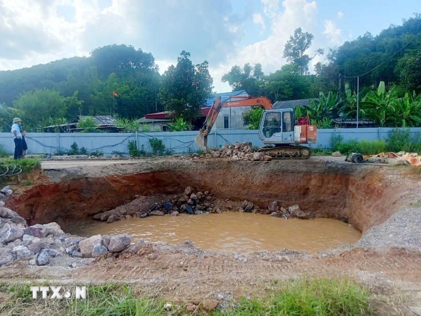 Đơn vị thi công tiến hành thả đá hộc xuống hố. (Ảnh TTXVN phát)