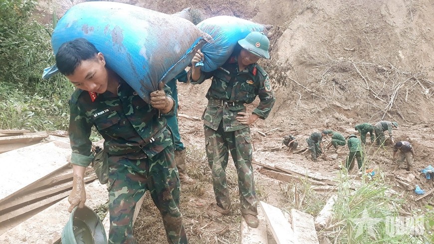 Cán bộ, chiến sĩ giúp người dân tại bản Háng Pu Xi, xã Xa Dung thu gom tài sản còn sót lại sau mưa lũ.