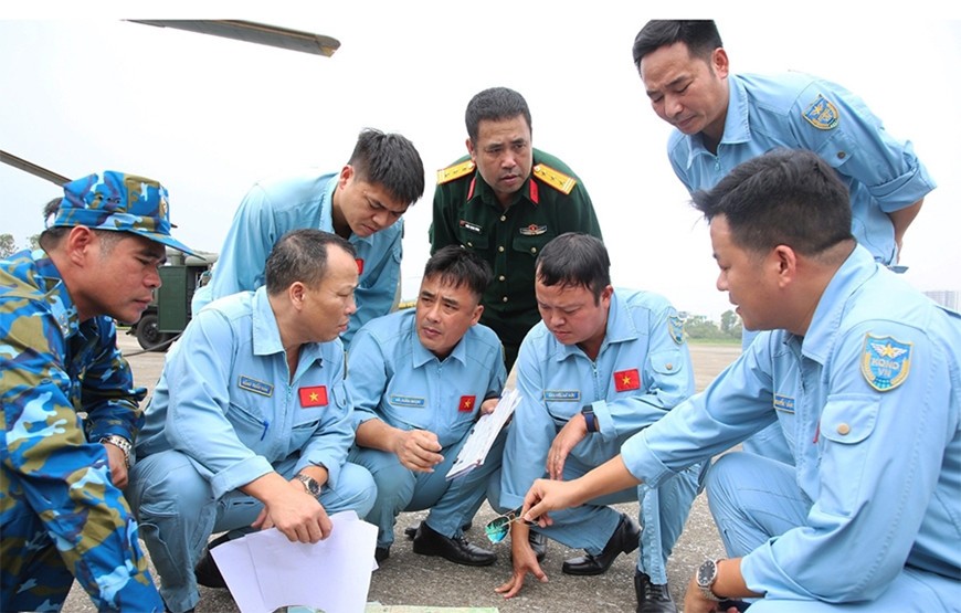 Phi công, thành viên tổ bay của Trung đoàn hiệp đồng phương án bay trước khi cất cánh bay cứu trợ tại Điện Biên.
