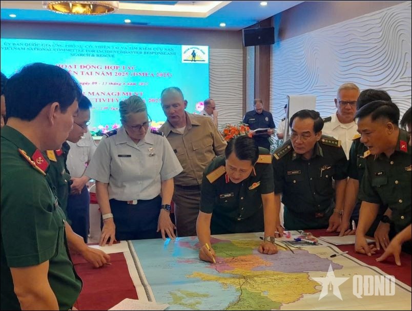 Thiếu tướng Phạm Hải Châu, Phó cục trưởng Cục Cứu hộ - Cứu nạn, tác nghiệp trên bản đồ, trao đổi với các đại biểu tại hội nghị hoạt động hợp tác quản lý thiên tai năm 2025. Ảnh: GIANG TRUNG 
