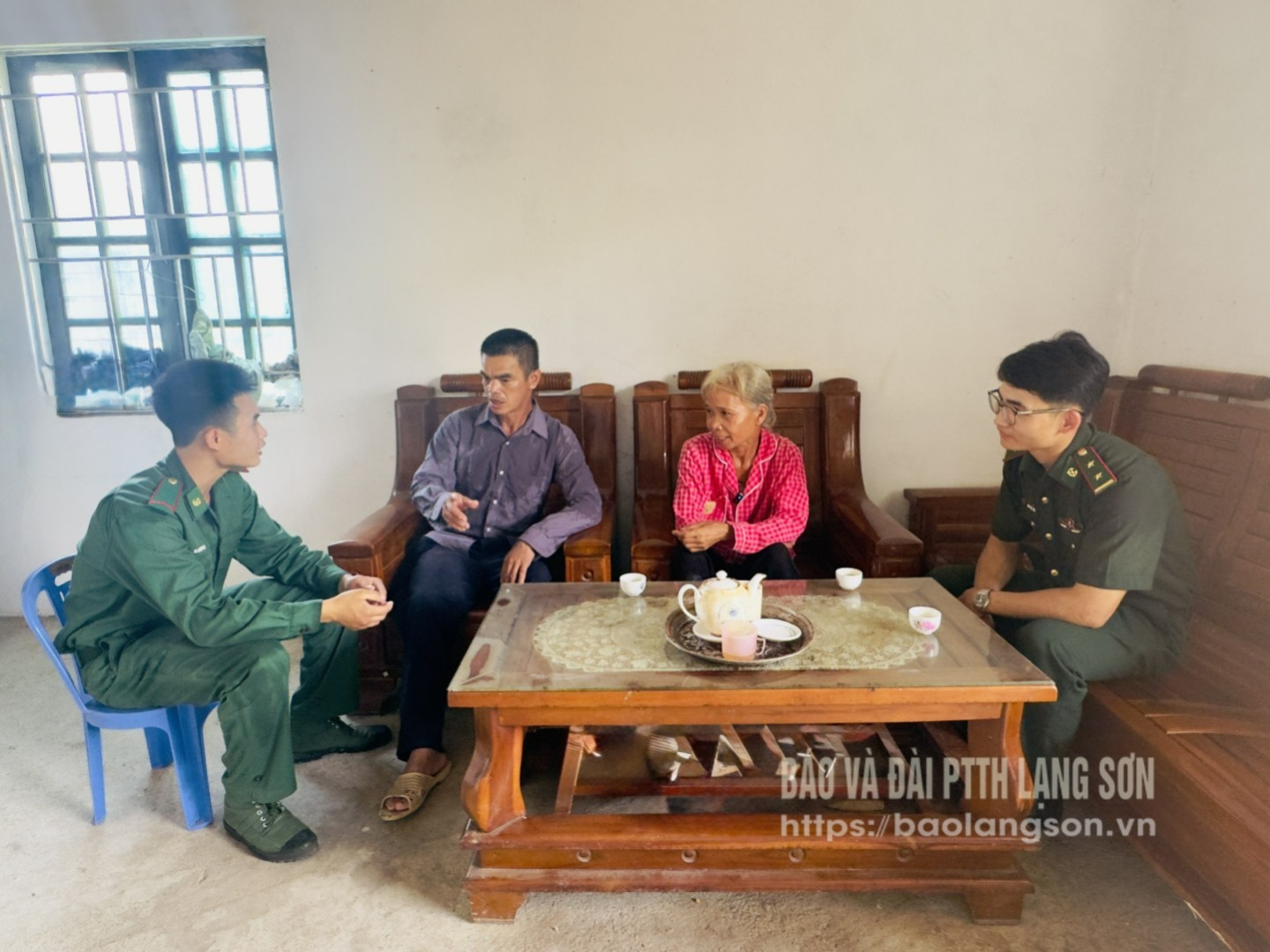 Ông Bế Văn Hòn và bà Ngô Thị Bạch thôn Bó Luông, xã Quốc Khánh đón tiếp cán bộ chiến sĩ Đồn Biên phòng Pò Mã trong ngôi nhà mới được hỗ trợ xây dựng 