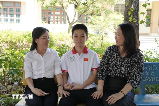 Dương Minh Tâm cùng cô giáo chủ nhiệm và mẹ. (Ảnh: Thanh Thủy/TTXVN)