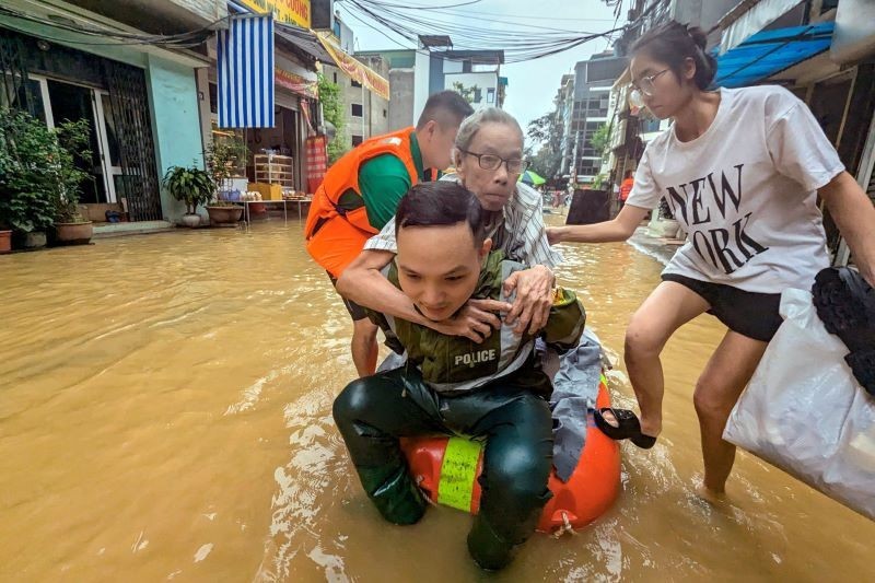 Công an Thủ đô cõng người già yếu ra khỏi khu ngập sâu ở phố Bạch Đằng bị ảnh hưởng bởi siêu bão Yagi) (Ảnh: Phú Khánh)
