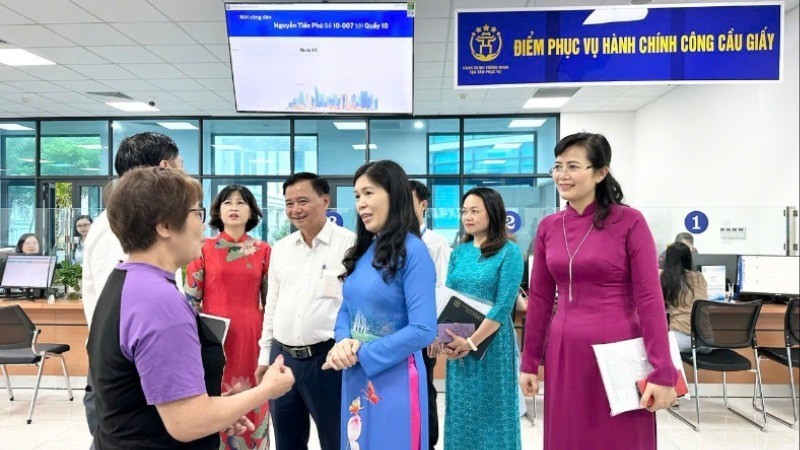 Lãnh đạo phường Cầu Giấy trò chuyện với người dân đến làm thủ tục hành chính. (Ảnh: HÀ PHONG)