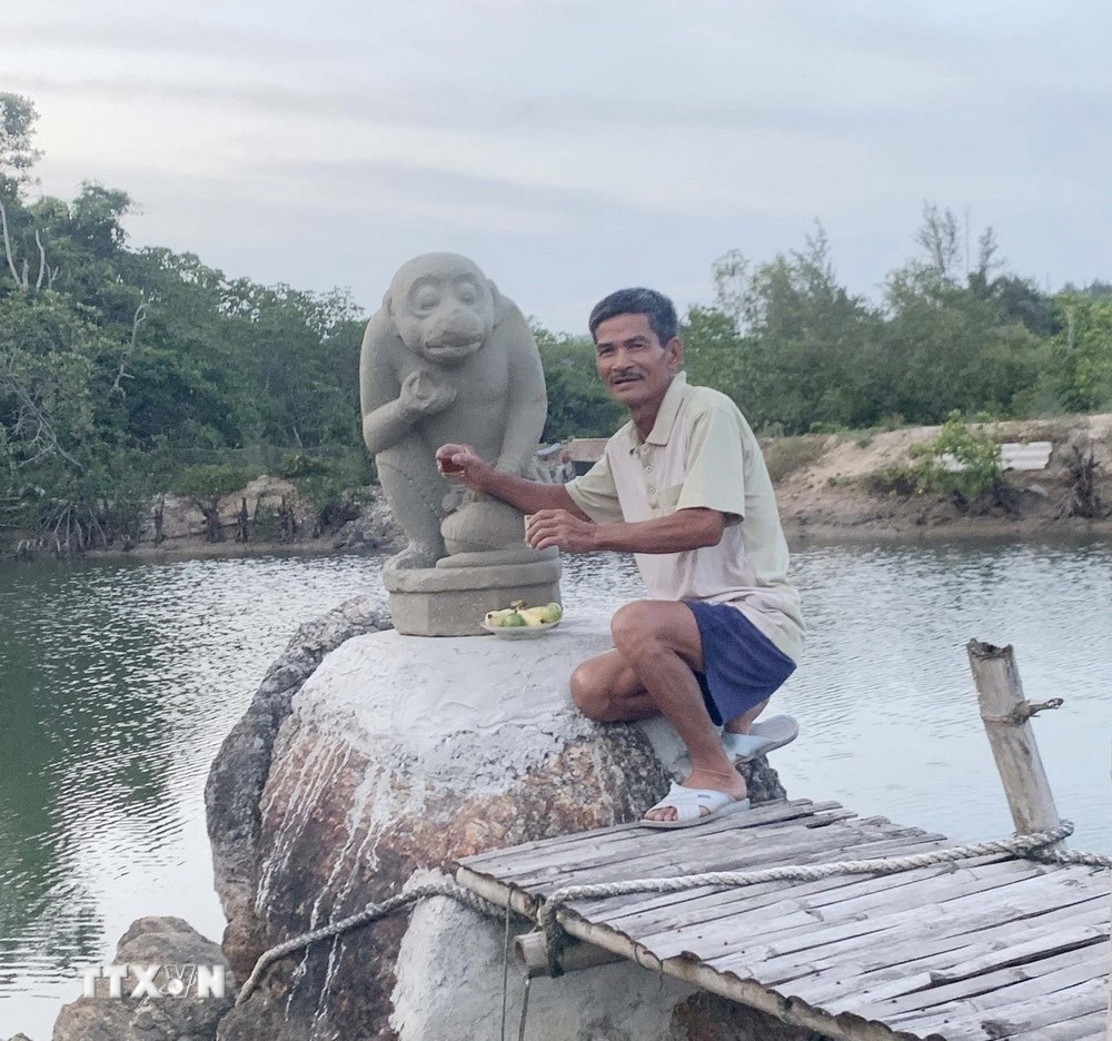 Ông Dương Đình Lục và tượng Khỉ Hanuman do ông trục vớt được. (Ảnh: TTXVN phát)