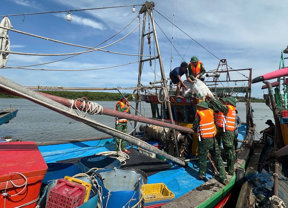 Bộ đội Biên phòng Nghệ An hỗ trợ ngư dân neo đậu tàu thuyền tại nơi tránh trú an toàn. (Ảnh: TTXVN phát)