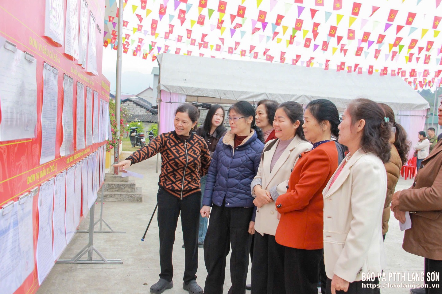 Cử tri xem lại danh sách, tiểu sử các ứng cử viên trước khi vào khu vực bỏ phiếu tại khu vực bỏ phiếu số 23, nhà văn hoá thôn 8, xã Na Sầm