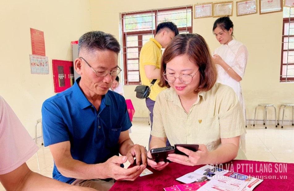 Chuyên viên Ủy ban MTTQ Việt Nam xã Đình Lập hướng dẫn người dân sử dụng các tiện ích số trên điện thoại thông minh