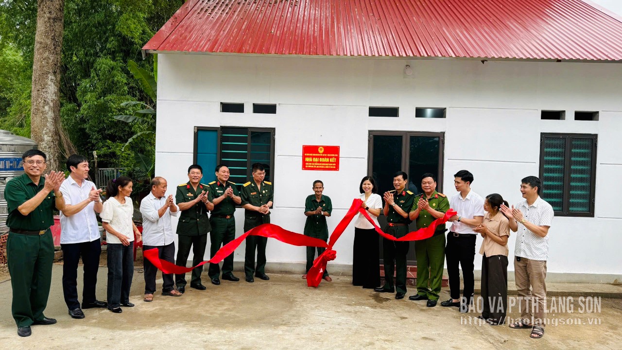 Các đại biểu kéo băng khánh thành ngôi nhà