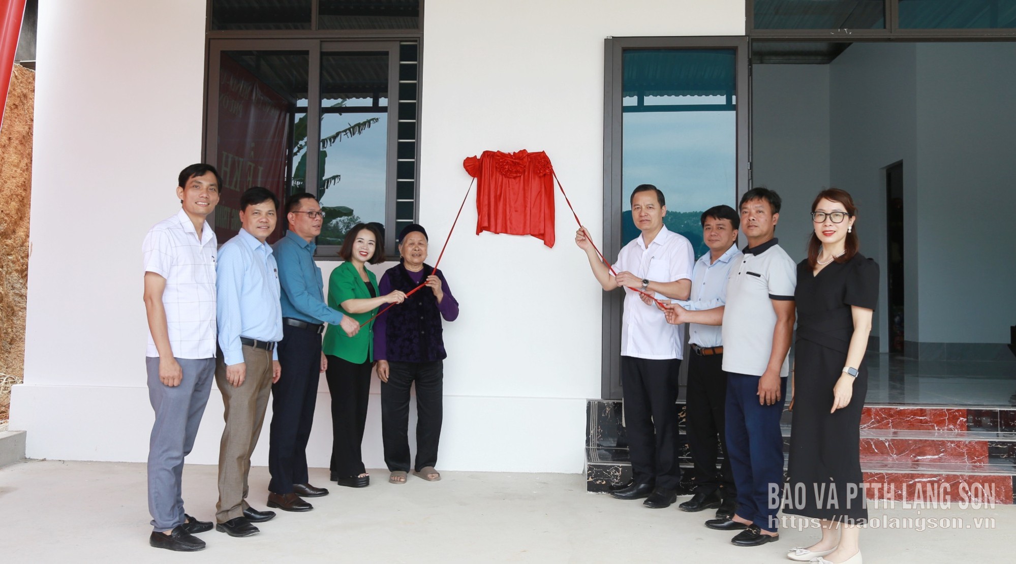 Các đại biểu thực hiện nghi thức kéo băng khánh thành nhà cho gia đình bà Nông Thị Ngay, ở khối Nà Soong, phường Đông Kinh