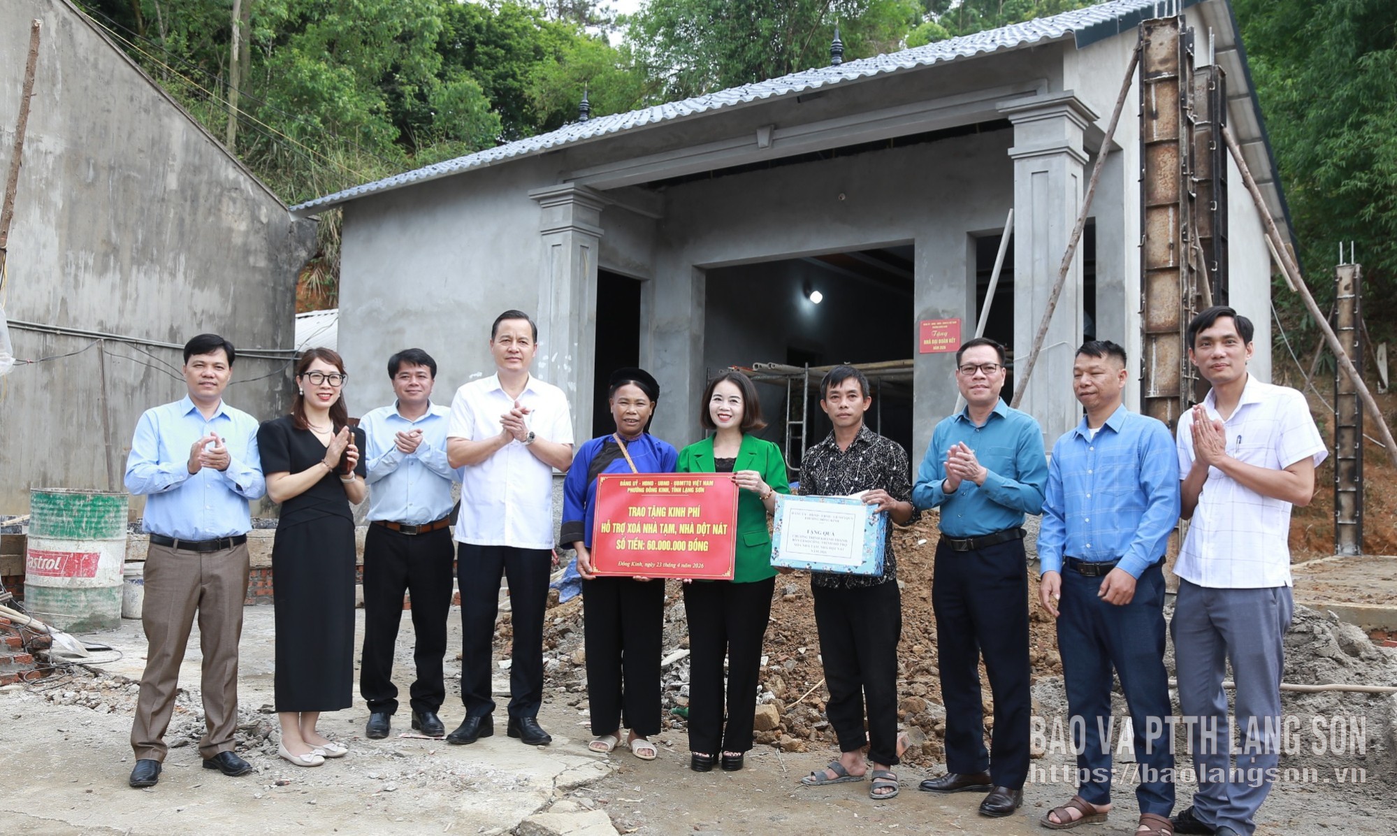 Các đại biểu trao quà và biển tượng trưng hỗ trợ kinh phí cho gia đình bà Vi Thị Nam, khối Yên Thủy I 