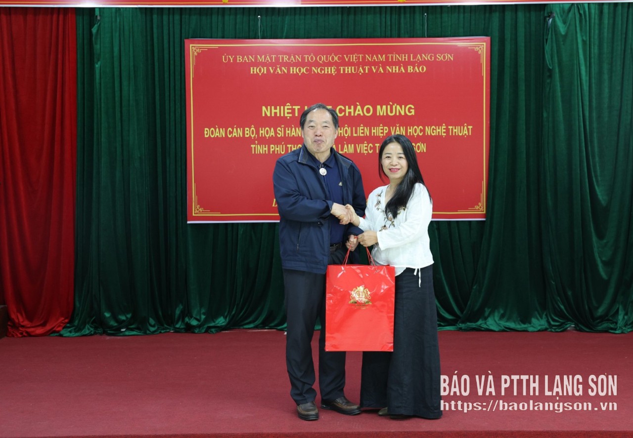 Đại diện đoàn cán bộ, họa sĩ Hàn Quốc (bên trái) tặng quà lãnh đạo Hội Văn học Nghệ thuật tỉnh Lạng Sơn