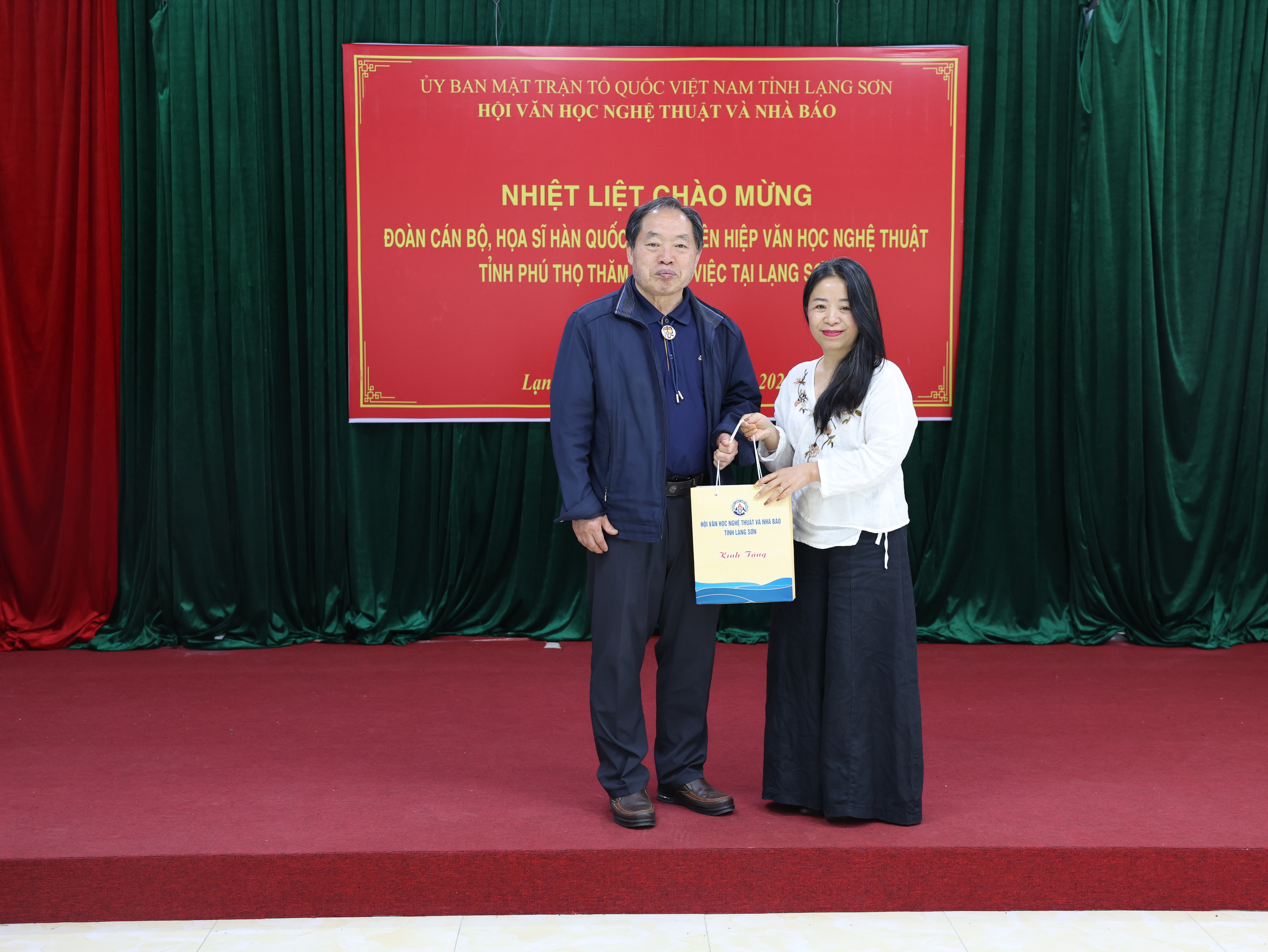 Đồng chí lãnh đạo Hội Văn học Nghệ thuật tỉnh Lạng Sơn (bên phải) tặng quà đại diện đoàn cán bộ, họa sĩ Hàn Quốc