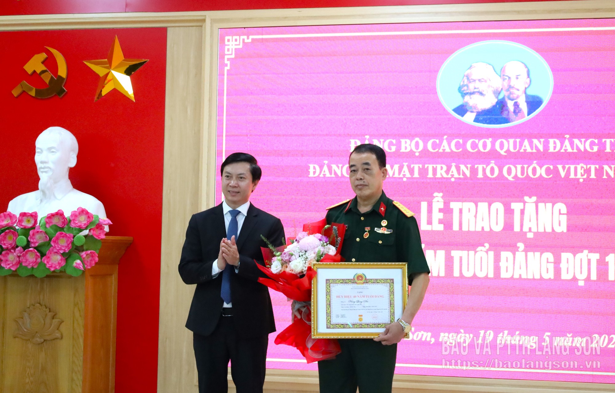 Đồng chí Nguyễn Hoàng Tùng, Ủy viên Ban Thường vụ Tỉnh ủy, Phó Bí thư Thường trực Đảng ủy các cơ quan Đảng tỉnh, Phó Chủ tịch Thường trực Ủy ban Mặt trận Tổ quốc Việt Nam tỉnh trao Huy hiệu 40 năm tuổi Đảng và tặng hoa chúc mừng đồng chí Nông Long Ân