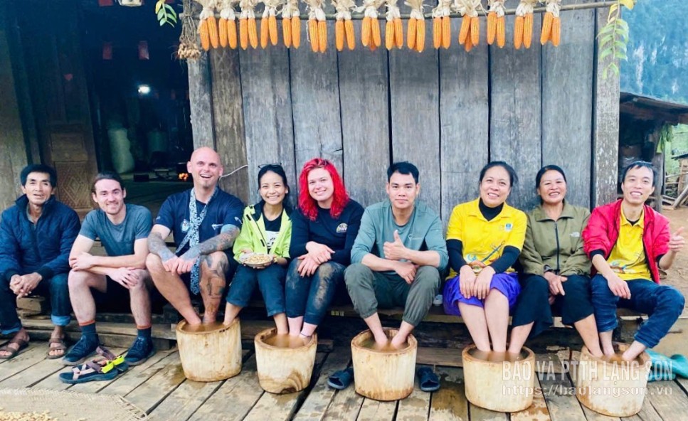 Người dân địa phương và khách du lịch nước ngoài trải nghiệm ngâm chân tại làng du lịch Lân Nóng, xã Cai Kinh  nằm trong vùng Công viên địa chất toàn cầu UNESCO Lạng Sơn