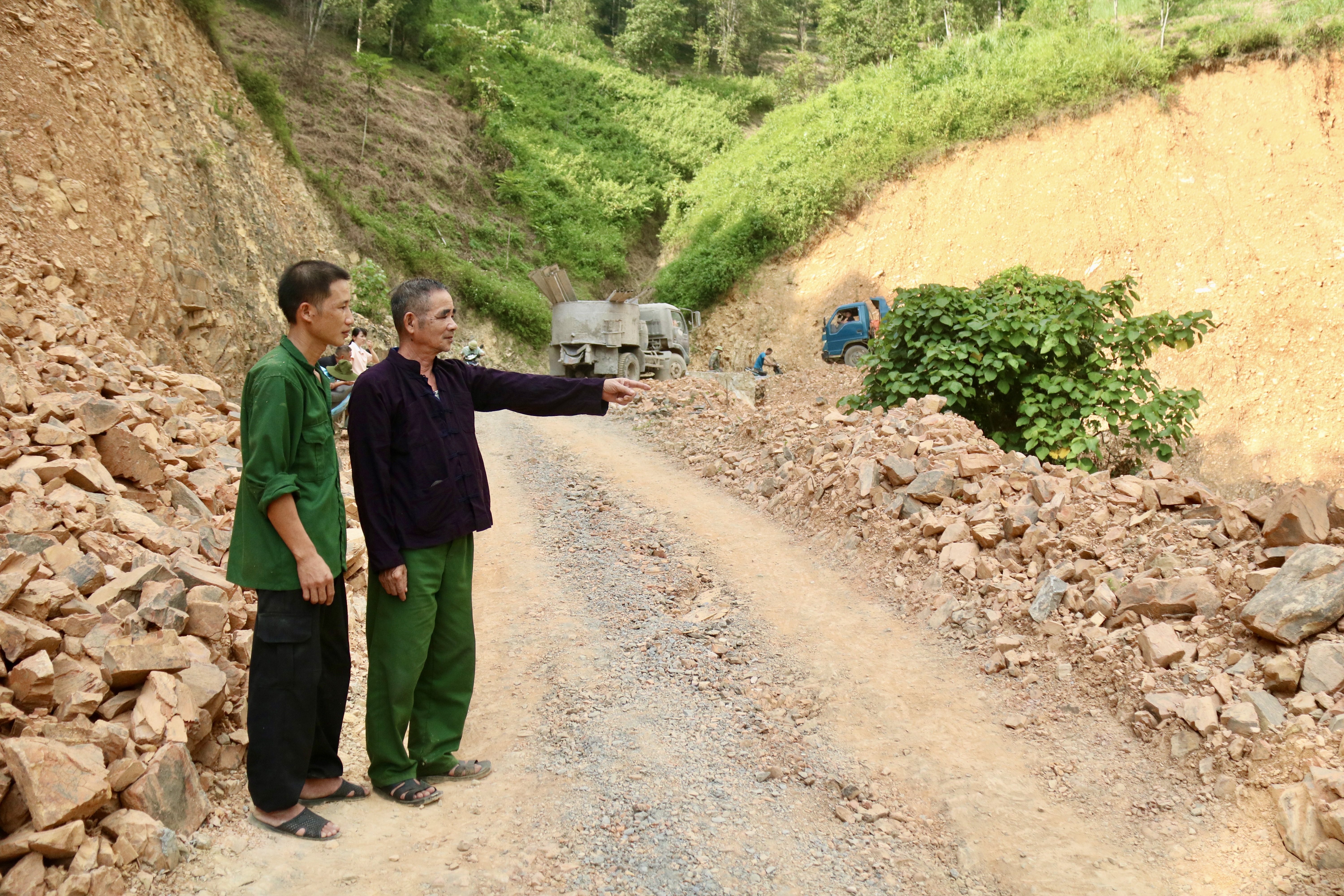 Ông Vi Văn Nhớn cùng người dân thôn Cao Minh trao đổi về đoạn đường đang được thi công.